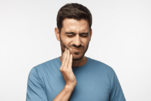 man holding jaw in pain